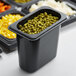 A black Cambro H-Pan container of peas and beans.