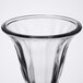 A close-up of a clear Libbey tulip sundae glass with a black rim.