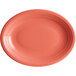 An Acopa Capri coral oval stoneware coupe platter with a white background and a bright orange rim.