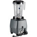 A Waring commercial food blender with a black lid and a cord attached to it.