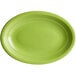 An Acopa Capri green oval stoneware coupe platter with a white border.