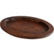 A Valor oval rubberwood skillet underliner with a rustic chestnut finish.