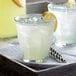 Two Duralex Picardie glasses of lemonade with ice and lemon wedges.