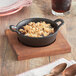 A Valor pre-seasoned cast iron bowl of food on a wood surface.