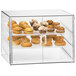 A Cal-Mil three tier pastry display case with food inside.