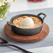 A Valor pre-seasoned cast iron serving bowl with a scoop of ice cream in it.