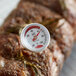 A Cooper-Atkins pocket probe thermometer placed on a piece of meat.
