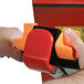 A close-up of a hand holding an orange switch on the Wesco Industrial Products Counter Balance Powered Stacker.