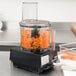 A Waring food processor with carrots being processed.