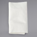 A folded white napkin on a gray surface.