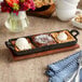A Valor pre-seasoned cast iron divided server with desserts on a table.
