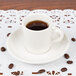 A Tuxton espresso cup of coffee on a white doily.