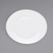 A white Front of the House Ellipse oval porcelain plate with a rim on a gray surface.