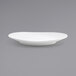 A close up of the front of a white Ellipse porcelain oval coupe plate on a gray surface.
