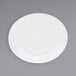 A close-up of a white Front of the House Ellipse porcelain plate with a white rim.