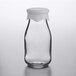 An Anchor Hocking clear glass milk bottle with a white silicone lid.