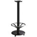 A Lancaster Table & Seating black cast iron bar height table base with a foot rest and table equalizers.
