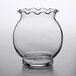 A clear glass Anchor Hocking footed votive with a wavy edge on a table.