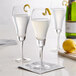 Three Anchor Hocking tulip champagne flutes filled with liquid and lemon wedges.