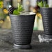 Two Acopa Alchemy hammered matte black mint julep cups with blackberry bourbon cocktails on a table.