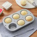 A Wilton Recipe Right muffin pan with cupcakes in paper wrappers.