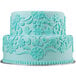A blue cake with a white ruffled design on it made using the Wilton Lace Silicone Fondant and Gum Paste Mold.
