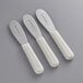 Three white plastic Dexter-Russell sandwich spreaders with scalloped blades and white handles.