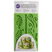 A green Wilton silicone mold with fern designs in a plastic package.