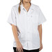 A woman wearing a white Uncommon Chef cook shirt.