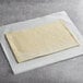 A Fiera Foods puff pastry dough sheet on white paper.