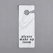 A white marble door sign with black text that says "Please Make Up Room"