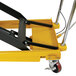 A yellow and black Wesco Industrial Products scissors lift table with wheels.