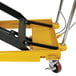 A yellow and black Wesco Industrial long deck scissors lift table with wheels.