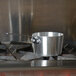 A Vollrath silver aluminum sauce pan on a stove.