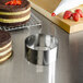 A Fat Daddio's stainless steel round cake mold on a table with a cake inside.