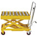 A yellow metal Wesco Industrial Products lift table with rollers.