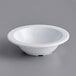 An Acopa Foundations white melamine fruit bowl on a gray surface.