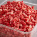 A plastic container of IQF 3/8" diced strawberries.