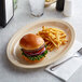 An Acopa tan melamine platter with a burger and fries on it.