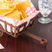 A brown rectangular polypropylene basket on a table with chips.