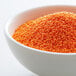 A bowl of orange nonpareils.