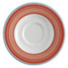 A white porcelain saucer with rolled edges and a circular coral and blue pattern.
