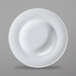 A close-up of a Corona by GET Enterprises bright white porcelain plate with a curved edge.