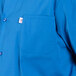A close up of a royal blue cook shirt with a white collar and pocket.