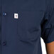 The back of a man wearing a navy cook shirt with a white pocket.