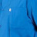 A close up of a royal blue cook shirt with a white collar.