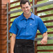 A man wearing a Uncommon Chef royal blue cook shirt.