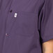 A man wearing a Uncommon Chef classic short sleeve cook shirt in purple with a pocket.