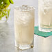 A glass of Boylan Ginger Ale with ice and a straw on a white background.