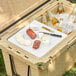 A CaterGator divider in a cooler with food and drinks on a table outdoors.